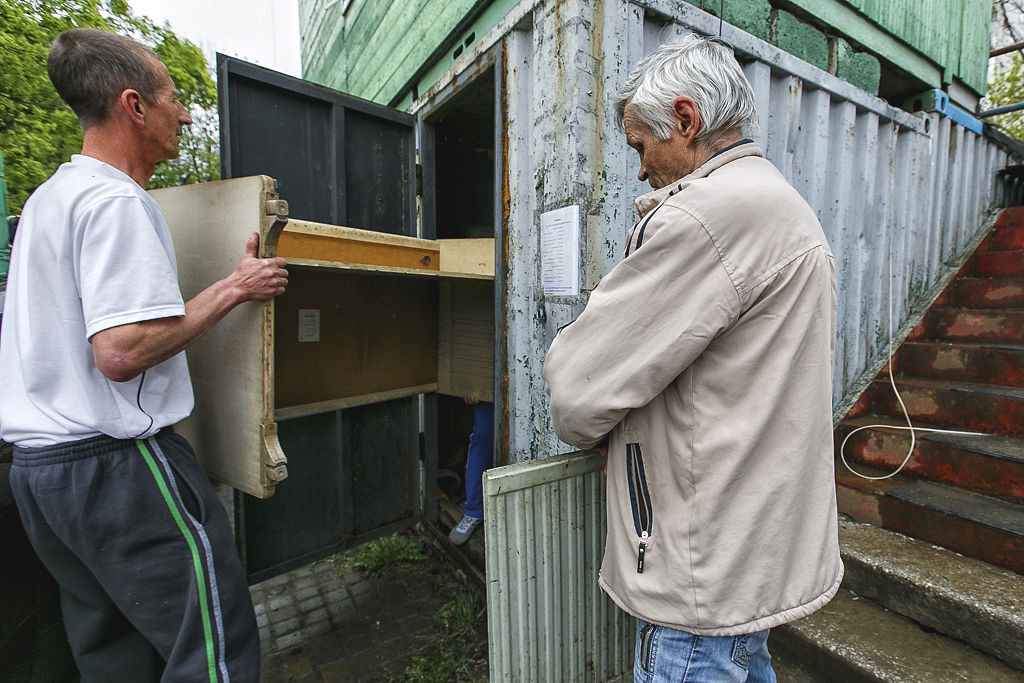 Свои вещи из верхнего этажа двухэтажной сторожки охранники перенесли на нижний этаж